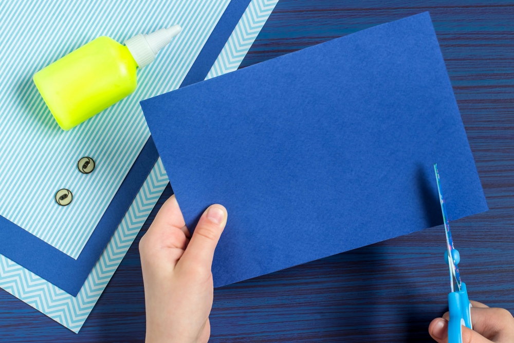 要製作恤衫領口位，要先在彩色紙上方輕畫一條橫線（距離頂部約3公分的位置），然後沿着橫線從兩邊各往內剪3公分。