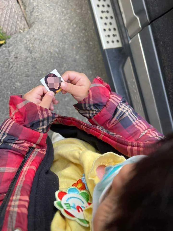 孩子拿著媽媽的照片便乖乖上學。