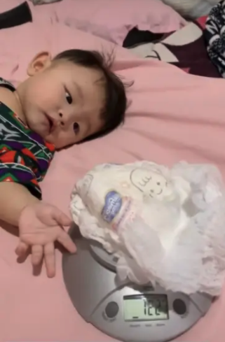 將兒子的尿片磅重。