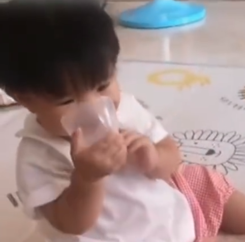 最初女嬰只是在蓋放入口中咬。