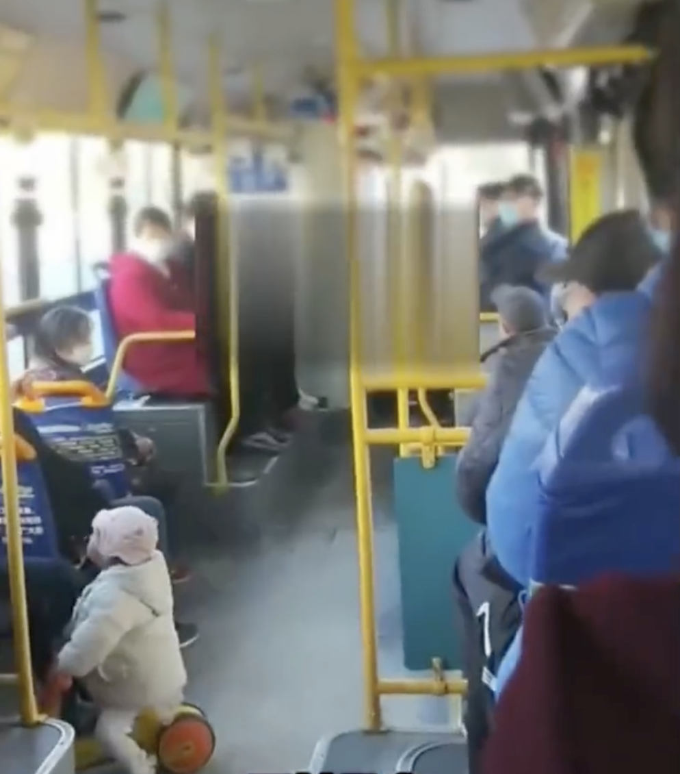 畫面中顯示左下角的女童依舊騎在玩具車上，一臉不解看著母親。