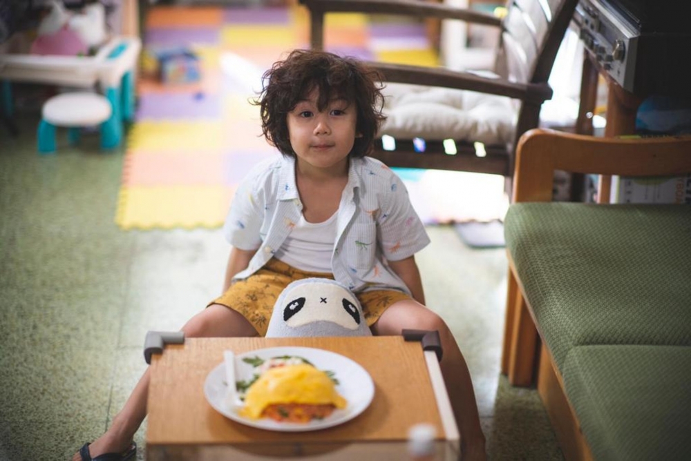 孩子只好乖乖坐定吃飯