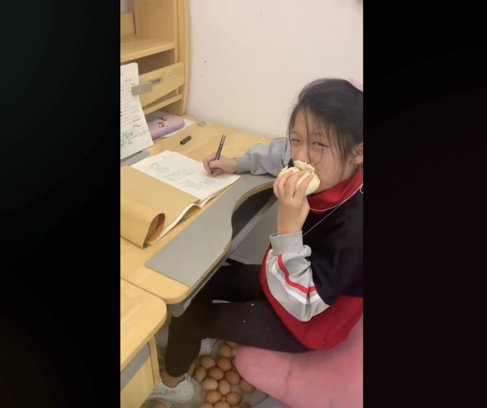 女兒一邊吃饅頭,一邊委屈做功課。