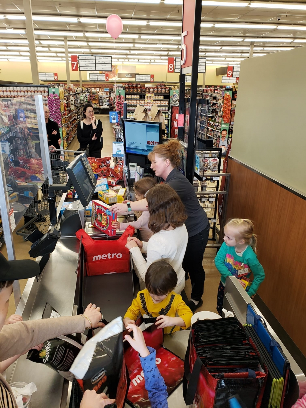 成班朋友在收銀機前扮收錢。