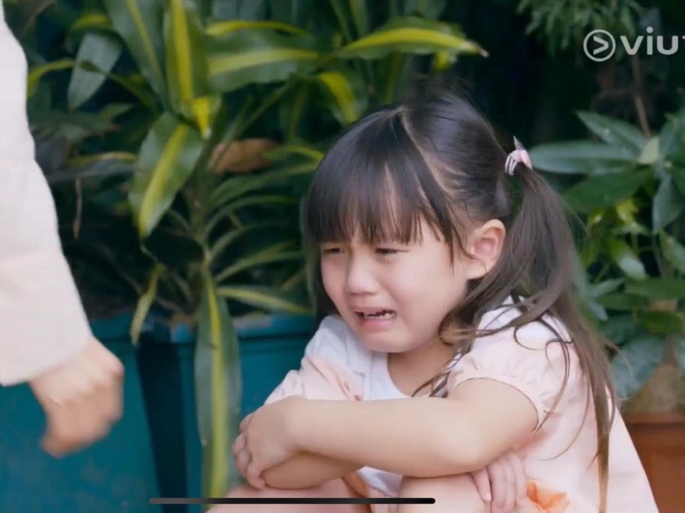 一名女童獨自站在街上前,孤苦伶仃