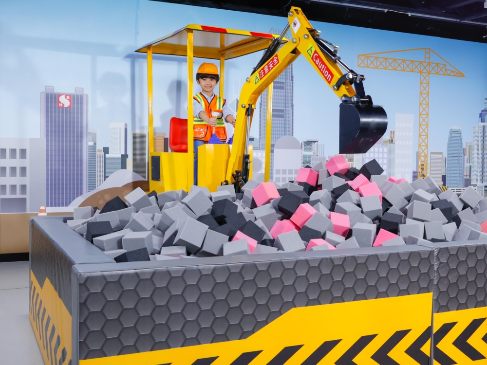 「智趣建築師大本營」讓小朋友學習挖掘機的操作。