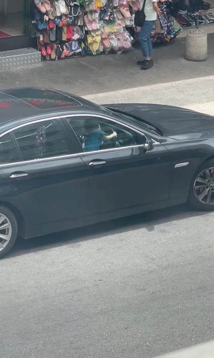 男童趴在軚盤上，更雙手轉動軚盤。