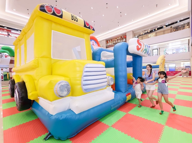 黃色學校巴士內有多重吹氣障礙物讓小朋友攀登。