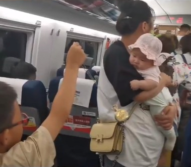 男孩取下身上的吊墜，在BB眼前左右搖晃。