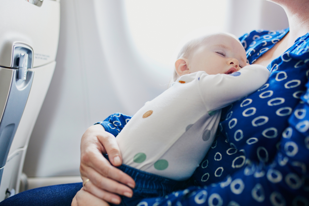 一名母親抱着嬰兒,身邊還有一個年幼兒童需照顧