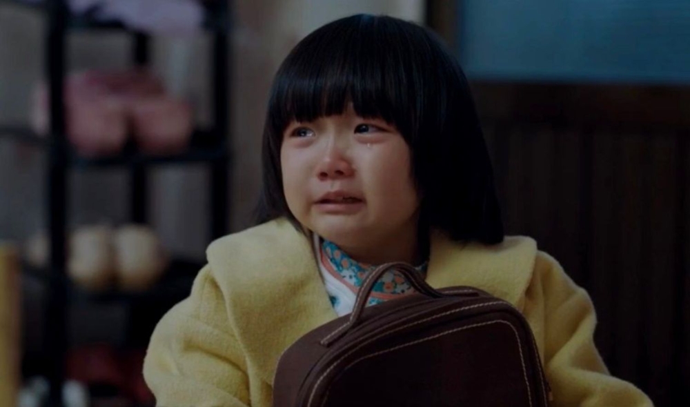 女兒哭著把信交給媽媽。