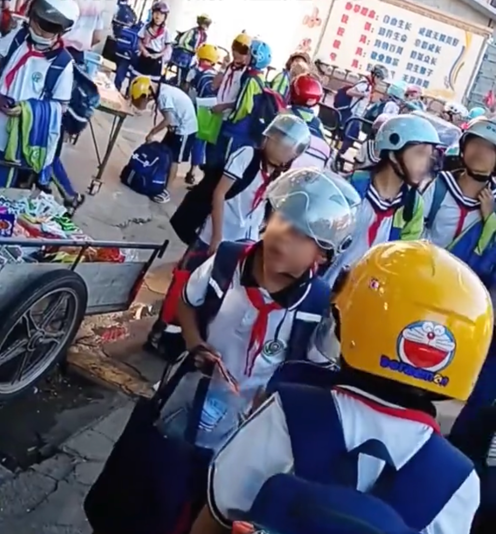 內地一間學校強制要求學生上下學要戴頭盔,引起爭議。
