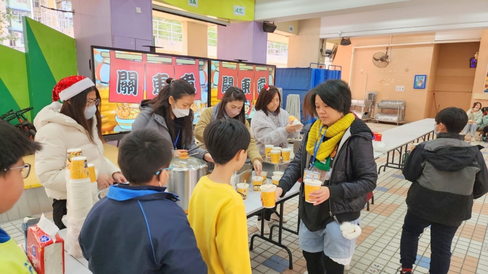 老師及家長義工在聖誕聯歡會向學生派關東煮。