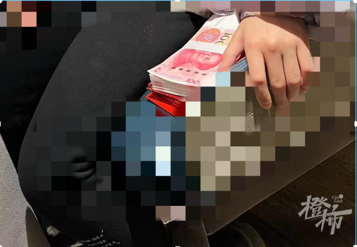 正在吃年夜飯的女孩身旁，擺放著一疊厚厚的百元人民幣利是。