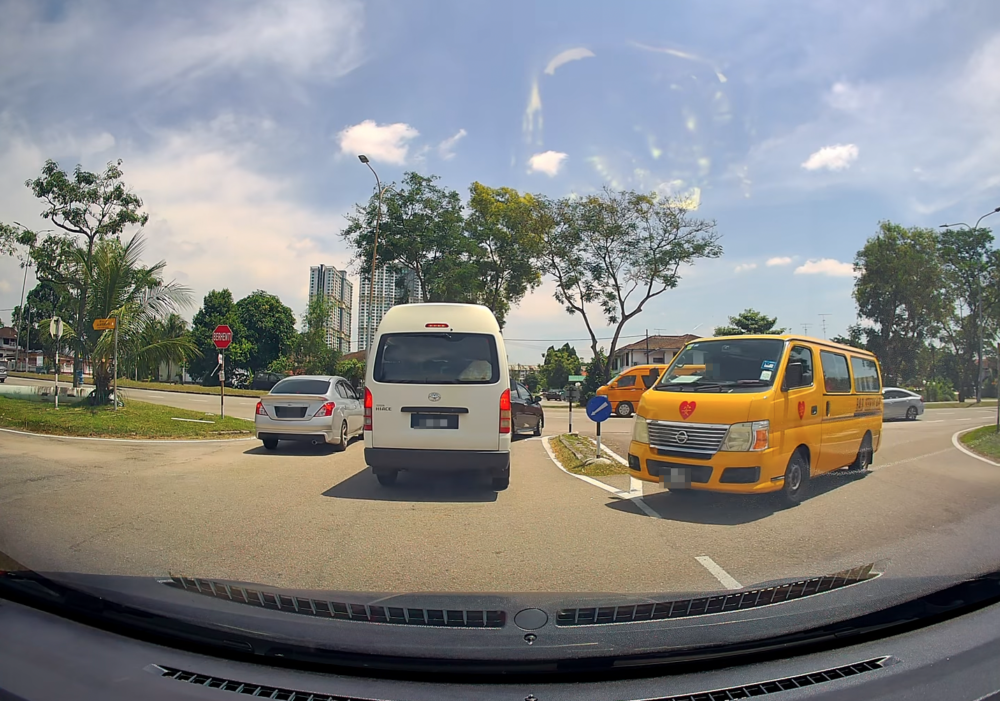 一位司機在駕駛途中讓路給一輛校巴先過。