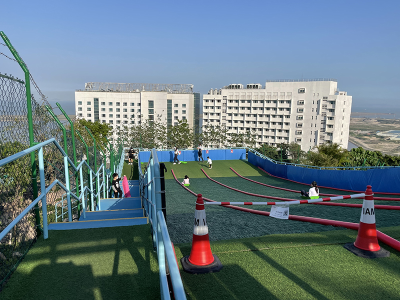 由於斜坡坡度不大,家長放心讓子女坐上滑草艇從高處滑下