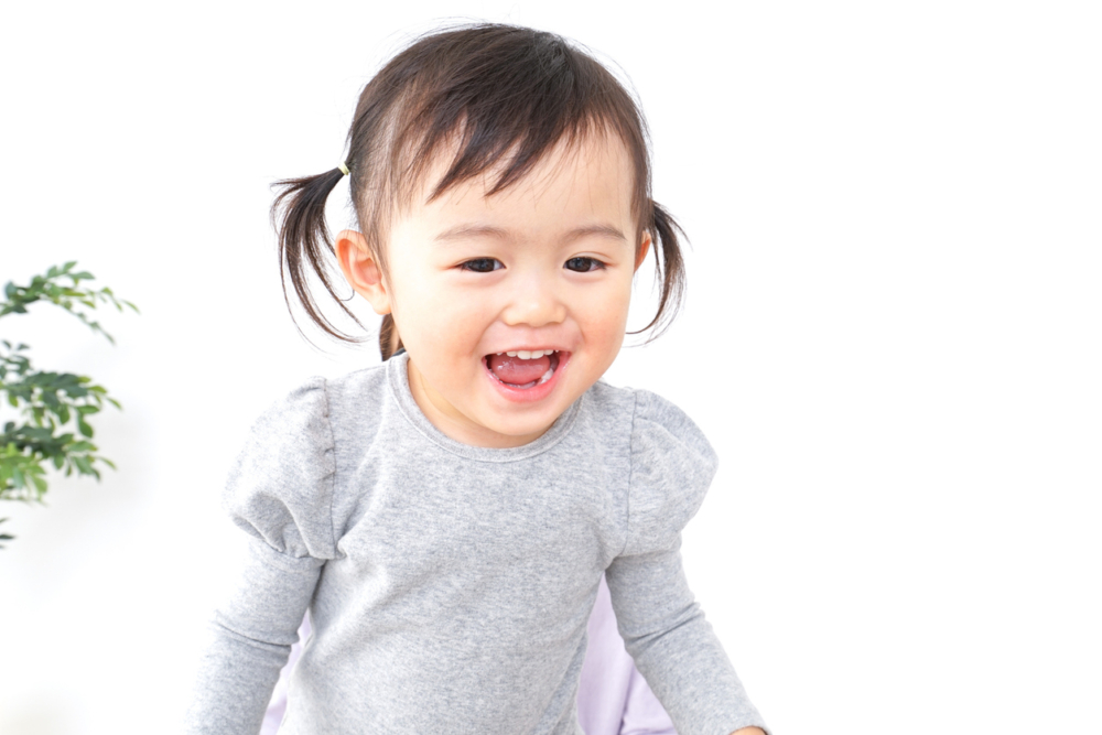 事主輕拍女兒的小手來提醒她「這樣不對」，但女兒反而笑得更開心，像是在跟父母玩遊戲