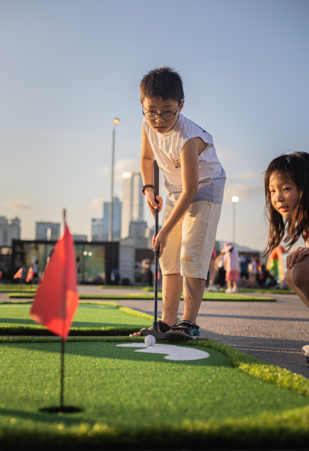 用力一揮,把哥爾夫球送進洞口