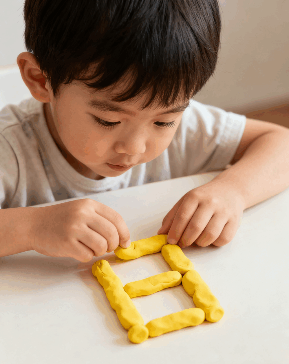幼兒利用泥膠砌出文字，除了可以認識文字的結構，亦可以加強小肌肉活動能力。